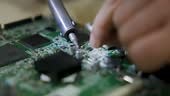 technician soldering a mother board circuit