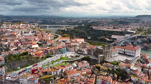 Cinematic generic aerial view of Porto downtown, Portugal. Panoramic view of Ribeira district with Porto Cathedral, Sé do Porto. Famous and historic travel destination. Drone forward, camera tilt down