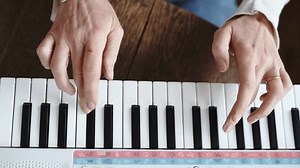 clip-1101118247-top-view-mature-woman-playing-piano-beginners