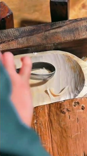 Hand-carving a smooth wooden basin using a curved scorp tool for an artisanal finish.