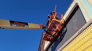 SPECTACULAR DAY AT THE SHELBY ROXY. Blue sky, no wind, not even the courthouse flag is stirring. Shaine and Weylin of R4R Construction taking advantage of a perfect day. They're wrestling with how the long metal pieces attach to the studs. Shaine is anxious for CAT Graphics of Great Falls to get the ROXY letters reinstalled in the recess on the facade. The temperature changes cause the metal panels in the recess to shrink and expand. The letters will hold that down. Until then, it's driving Shai