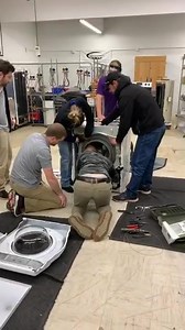Live feed of the class breaking down a front load washer for a bearing repair. | Fred's Appliance Academy