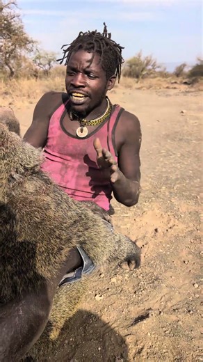 A Hadza Hunter Relaxing and Playing with Baboons