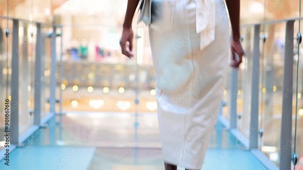 black woman walking on a glass floor, in a tight skirt