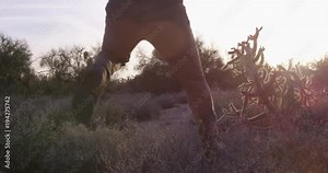 American cowboy running away from danger through desert - slow motion