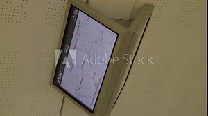 Inside a German ICE train, a digital map display shows train route information