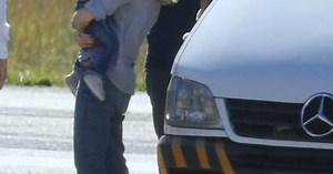 É a cara da mãe? Sandy embarca com filho Theo no colo