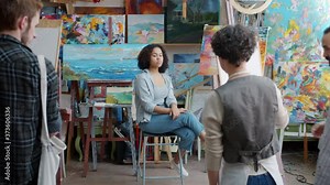 Group of students young people are drawing portrait of attractive Afro-American girl model in art class while teacher is walking around teaching