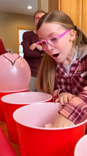 Valentine's Day Family Ball Roll ❤️ Mom, Dad, kids, and the whole family play fun festive Valentine's Day table game where they try to roll ping pong balls into a cup then pop balloons for prizes. One of them is a special prize that is worth more than all the rest. This video was produced by Benson Crew, Network Media, and Benson Bros. | Paul & Kezzy
