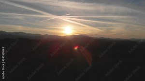 An epic view of the Smoky Mountains at Sunset. the shot is exposed for the sun, leaving a silhouette of the ridge visible as camera dollies towards the sun.