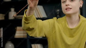 Close-up of female psychologist hypnotizing patient using pendulum, to create state of focused attention and increased suggestibility in treatment of psychological disorder at office.