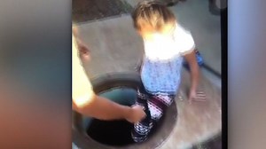 Man helps young girl into manhole in Hawaii