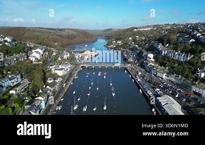 Looe, Cornwall, England: DRONE VIEWS: The drone flies over the course of the East Looe river showing West and East Looe. Looe is an ancient fishing port and popular UK holiday destination (Clip 2 of 6).