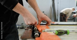 A close-up of a technician's hands working on the repair of an electric car battery pack in a modern workshop setting. Technician Repairing Electric Car Battery Pack in Workshop. Electric car.