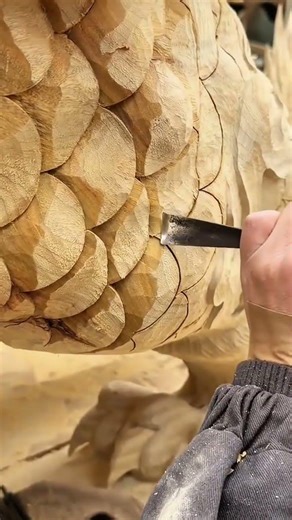 performing wood carving art on bird feathers pattern with traditional tools and detailed techniques