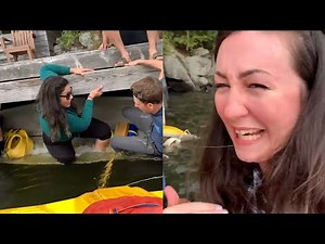 Woman Holds Onto Dock as Canoe Tips Over and Onlookers Laugh