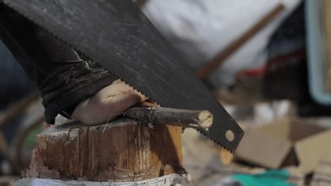 clip-3989570969-close-up-male-hands-using-hand-saw-cut