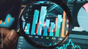 A hand holds a magnifying glass over a vibrant digital display of financial charts, including dynamic bar graphs and colorful pie charts, emphasizing data analysis and investment insights. Stock Video
