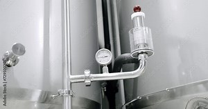 Detail view of detectors for measuring pressure in reservoirs on producing beer. Thermostat temperature going up. Grain of malt in a beer tank in a factory. Boiling grain malt. brewery. Making beer.