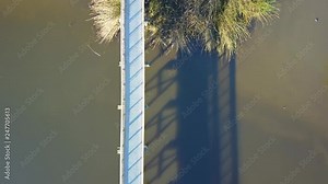 Top down aerial drone shot of boardwalk in-between a lake in Oso Flaco, located on the Central Coast of California, Santa Barbara County