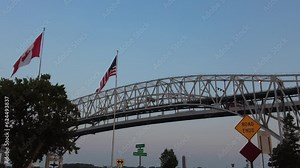 American And Canadian Flags Left Side Blue Water Border Crossing Bridge