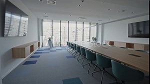 Modern Meeting Room with Chairs, Conference Table and Two TV's. Corporate boardroom interior with minimalist design. Comfortable seating in a contemporary workspace