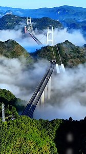 Located in Jishou, #Hunan Province, the Aizhai Bridge spans the deep and dramatic Dehang Canyon, serving as a vital link in the expressway connecting Chongqing Municipality to Changsha, the capital of Hunan. #ChinaInfrastructure Watch it from above: Nestled among misty peaks, the bridge seems to float between the clouds, a bold ribbon of steel defying nature's barriers. | Xi's Moments