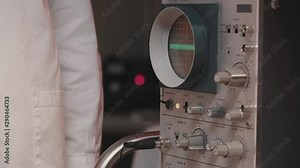 Scientist adjusting the oscilloscope settings in the lab