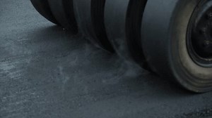 Process of asphalting road construction infrastructure by compressing, compacting, leveling and smoothing the asphalt road surface using a pneumatic tyred roller