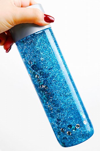 Let it snow... in a bottle! ❄️✨ Learn how to turn recycled water bottles into magical winter sensory bottles for kids. With glitter, tiny snowflakes, and baby oil, you can make it snow anytime, no mittens required! 😉 https://onelittleproject.com/winter-sensory-bottles/ | One Little Project