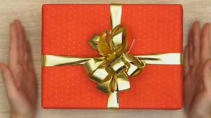 clip-1021905013-hands-putting-gift-box-on-table-present