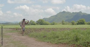 Farmers have farms next to the mountains that make the view look beautiful.Farmer wearing a red shirt with brown stripes shirt spraying toxic pesticides at the grass tree.