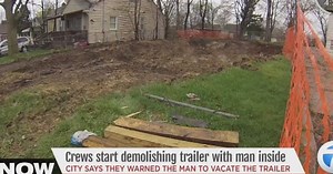 Crews begin demolishing trailer with man inside