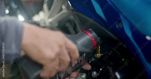 Refueling and pouring oil quality into the engine motor car.Add new oil to the engine.Close up of Hand Car Mechanic Refueling and Pouring Oil Fill the Oil in the Engine.