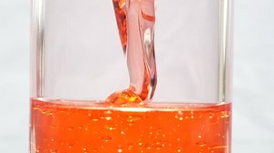 Abstract red liquid pouring down the hitting surface, Close Up Macro