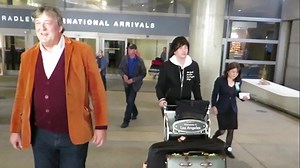 Stephen Fry is upbeat as he arrives in Los Angeles with husband