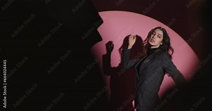 Backstage professional fashion photo shoot. Stylish fashion photo shoot model girl in black trouser suit. Model looks at photographer, conveys vibe and emotions through poses and facial expressions.