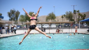 Enjoying a cool plunge and a sweet treat, locals help to keep a community pool open