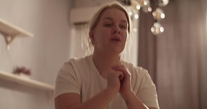 Young plus size woman squatting during workout at home