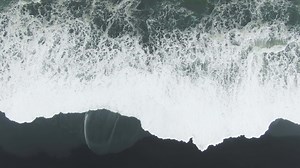 Ocean Crashing Waves. Reynisfjara Black Sand Beach, Iceland. Aerial Vertical Top-Down View.