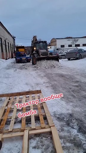 Large Backhoe Loader Moving Concrete Slabs in Winter