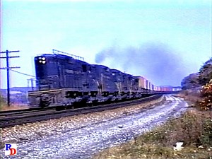 A Pennsylvania Railroad truck train passes by in its entirety during the ealy 1960s near Latrobe, Pennsylvania. What a sight, with names and logos of dozens of trucking & railroad companies from the era! From the A&R Productions show "The Pennsy and more! The Standard Railroad of the World” https://rfd.video/PennsyMore | Railfan Depot