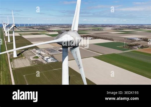 Aerial view of the Noordoostpolder battery park beside Westermeerdijk wind farm in the Netherlands, showing grid storage, renewable energy infrastructure, and the energy transition Stock Video Footage - Alamy