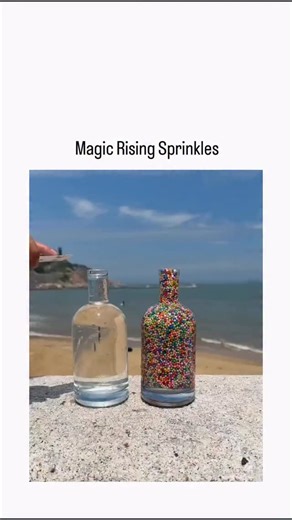 Brainbites.io on Instagram: "The post features video demonstrating a physics experiment using two connected glass bottles on a beach: water poured into the upper empty bottle creates a pressure differential, causing colorful sprinkles in the lower bottle to rise through the tube via buoyancy and fluid flow, forming a vibrant, hourglass-like ascent. This setup illustrates hydrostatic pressure and Archimedes’ principle, where denser water descends, displacing lighter air and particles upward; a 20