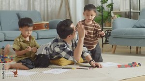 Full Body Of Asian Father And Sons On The Floor In The Room With Plastic Toy Brick Drawing Together At Home. Clapping Hands And Giving High Five Celebrating On Success Drawing