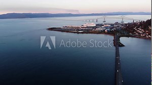 Aerial seascape view of Astoria sunset cityscape with New Youngs Bay bridge connecting Washington with Oregon. Drone fly above Columbia river revealing stunning skyline
