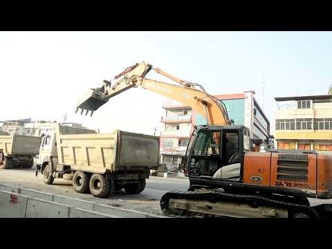 Loading a tipper truck dangerously on the main road in excavator