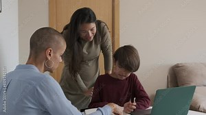Lesbian mothers helping a non-binary child to do homework at home