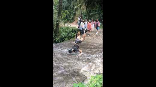 Man crosses shallow river while performing handstand in Kathmandu, Nepal