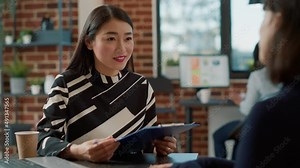 Female recruiter interviewing woman with work experience on cv. Employee analyzing resume information and talking about corporate employment at job interview with confident candidate.